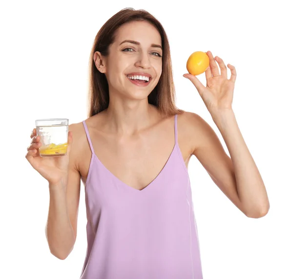 Mujer joven con vaso de agua de limón sobre fondo blanco — Foto de Stock