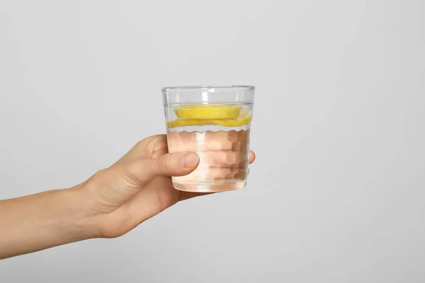 Mujer joven con vaso de agua de limón sobre fondo claro, cerca —  Fotos de Stock