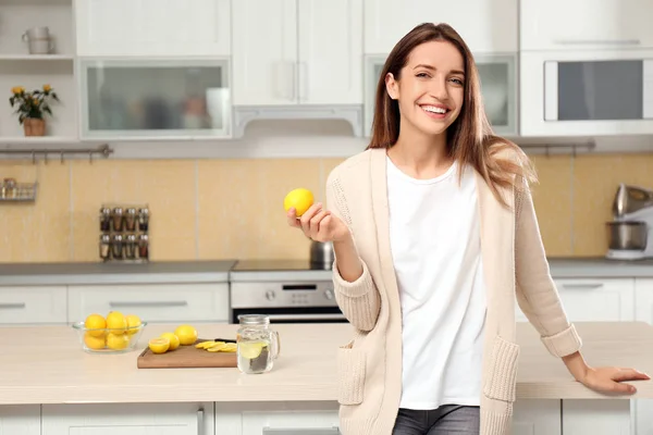Mujer joven con limón fresco en la cocina — Foto de Stock