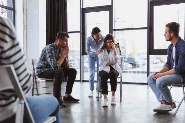 Psychotherapist working with patients in group therapy session indoors