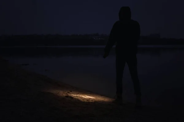 Człowiek Latarką Spacerujący Nocą Nad Rzeką — Zdjęcie stockowe