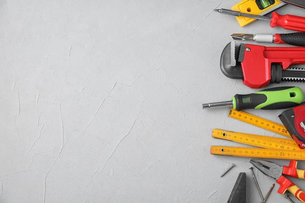 Composición plana con herramientas de construcción sobre respaldo gris claro —  Fotos de Stock