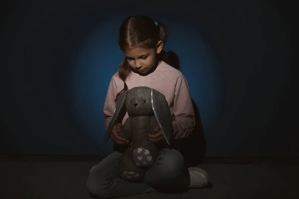 Fetiţă tristă cu jucărie lângă peretele albastru. Violența domestică conce — Fotografie, imagine de stoc