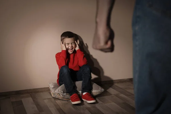 Um homem a ameaçar o filho dentro de casa. Conceito de violência doméstica — Fotografia de Stock