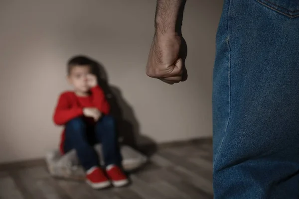 Человек угрожает своему сыну в помещении, крупным планом. Конк домашнего насилия — стоковое фото