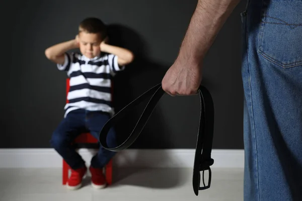 Uomo che minaccia suo figlio con la cintura in casa, primo piano. Domestico vio — Foto Stock