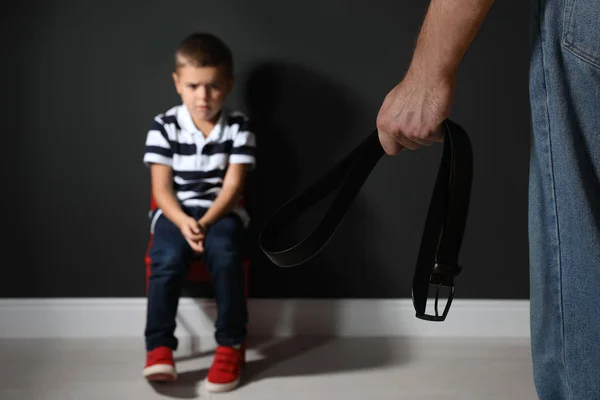 Uomo che minaccia suo figlio con la cintura in casa, primo piano. Domestico vio — Foto Stock