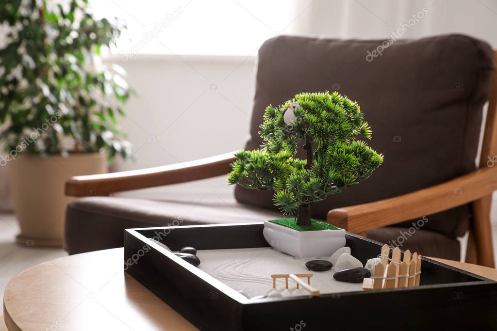 Beautiful miniature zen garden on wooden table indoors