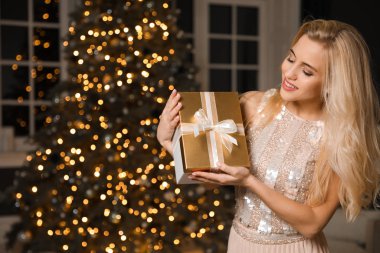 Süslü odada hediye kutusu olan güzel bir kadın. Noel kutlaması