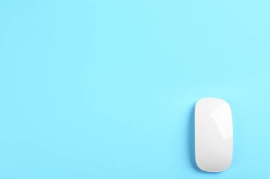 Açık mavi arka planda modern kablosuz optik fare, üst görünüm. Metin için boşluk