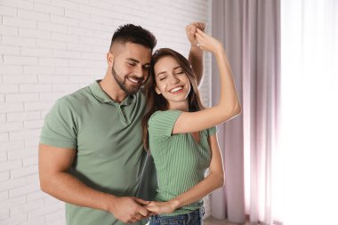 Güzel genç çift evde dans ediyor.