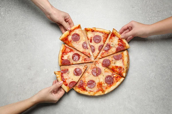 Persone Che Prendono Fette Gustosa Pizza Salame Piccante Tavolo Grigio — Foto Stock
