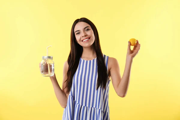 Красива молода жінка зі смачною лимонною водою і свіжими фруктами на — стокове фото