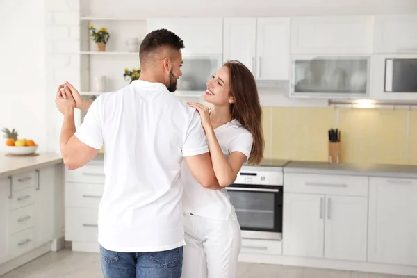 Adorável jovem casal dançando na cozinha em casa — Fotografia de Stock