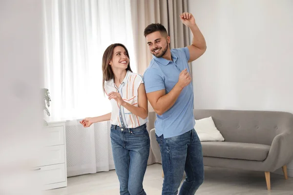 Adorável jovem casal dançando juntos em casa — Fotografia de Stock