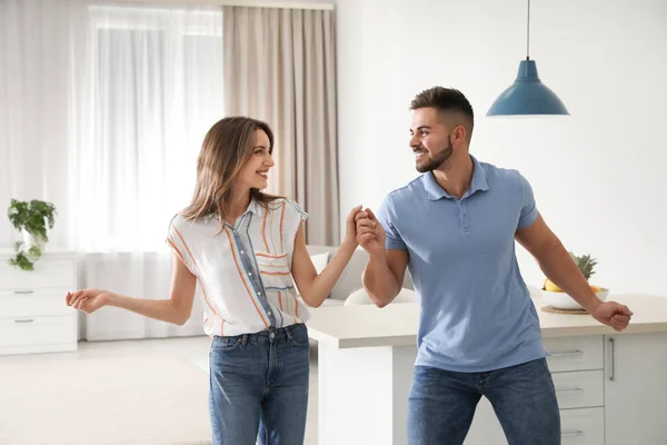 Adorável jovem casal dançando na cozinha em casa — Fotografia de Stock