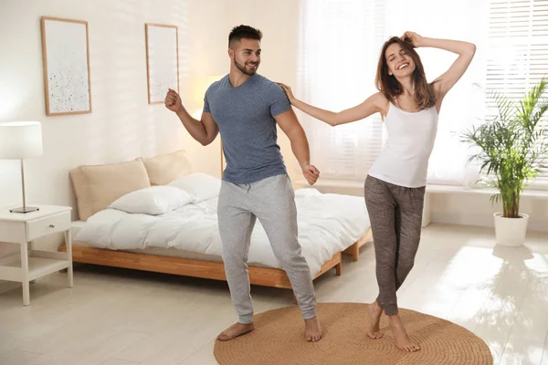 Прекрасная молодая пара танцует дома в спальне — стоковое фото