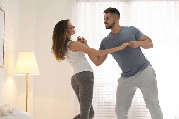 Adorável jovem casal dançando no quarto em casa — Fotografia de Stock