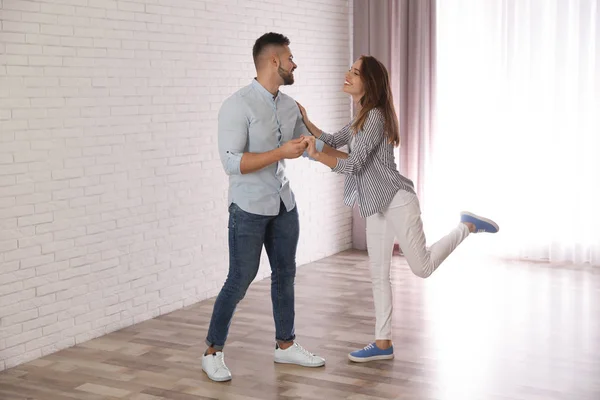 Charmant jeune couple dansant ensemble à la maison — Photo