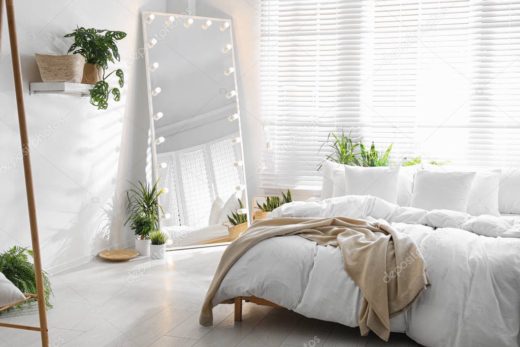 Stylish mirror with light bulbs in modern bedroom. Interior design