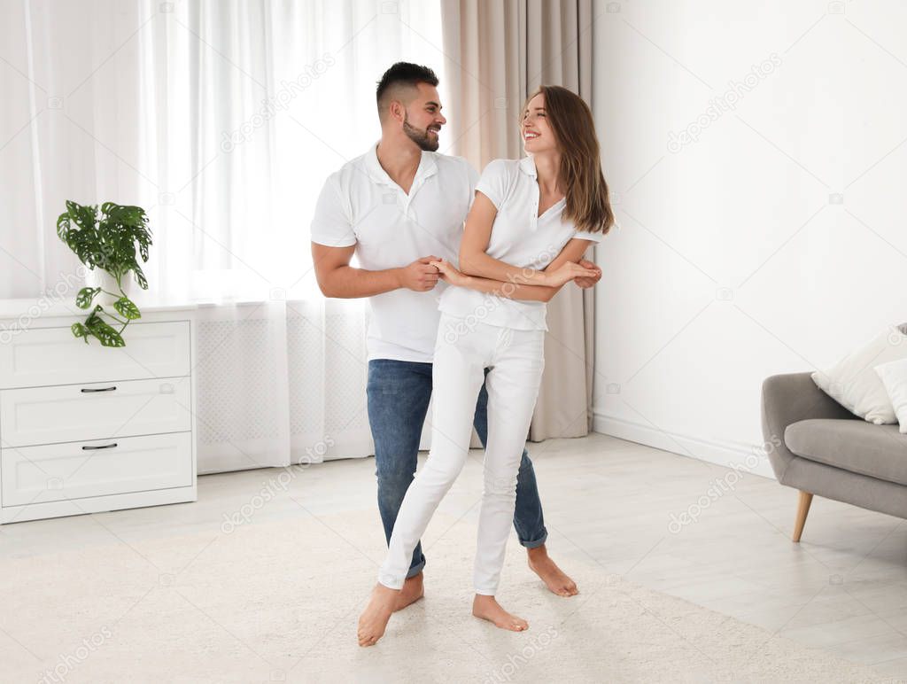 Lovely young couple dancing together at home