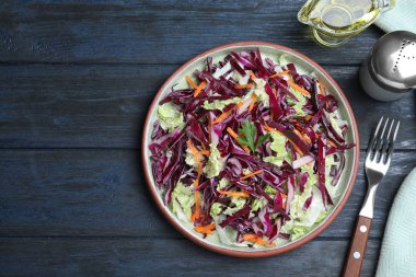 Mavi ahşap masada servis edilen taze lahana salatası.