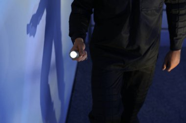 Karanlık odada feneri olan erkek güvenlik görevlisi, yakın plan.