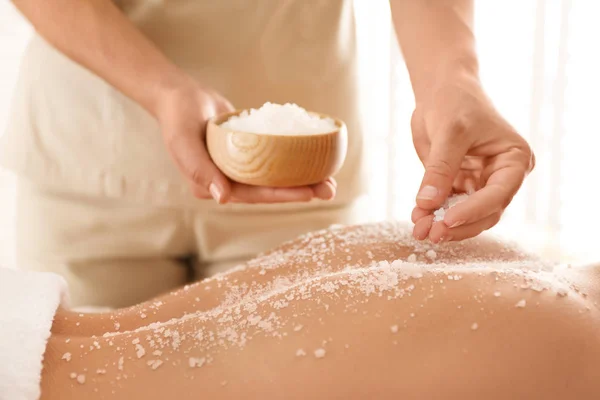 Young woman having body scrubbing procedure with sea salt in spa — Stock Photo, Image