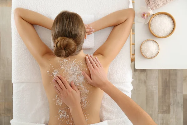 Jovem mulher tendo procedimento de limpeza corporal com sal marinho no spa — Fotografia de Stock