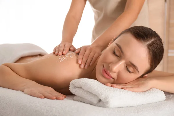 Jovem mulher tendo procedimento de limpeza corporal com sal marinho no spa — Fotografia de Stock