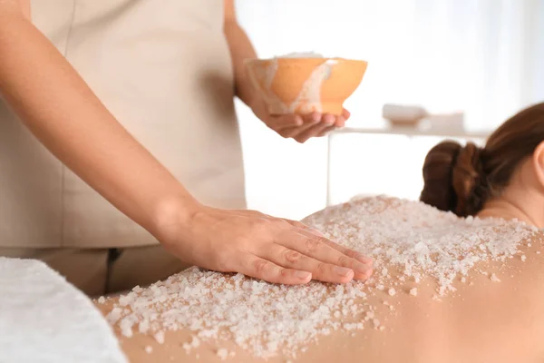 Jovem mulher tendo procedimento de limpeza corporal com sal marinho no spa — Fotografia de Stock