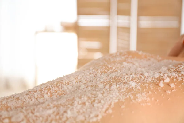 Young woman having body scrubbing procedure with sea salt in spa — Stock Photo, Image