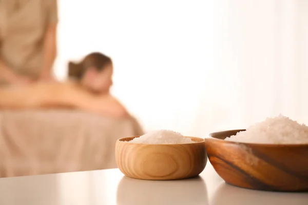 Tigelas com sal marinho na mesa branca no salão de spa — Fotografia de Stock