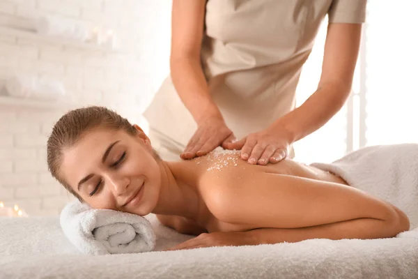 Jovem mulher tendo procedimento de limpeza corporal com sal marinho no spa — Fotografia de Stock