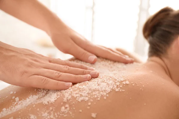 Jovem mulher tendo procedimento de limpeza corporal com sal marinho no spa — Fotografia de Stock