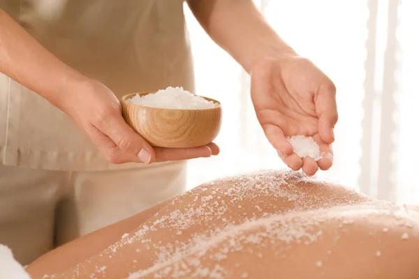 Jovem mulher tendo procedimento de limpeza corporal com sal marinho no spa — Fotografia de Stock