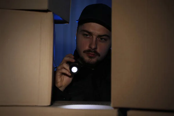 Elinde Fener Olan Güvenlik Görevlisi Karanlık Odadaki Karton Kutulara Bakıyor — Stok fotoğraf