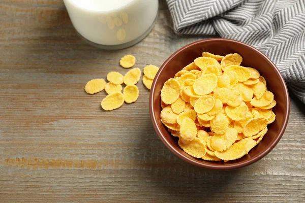 Tasty corn flakes on wooden table, above view