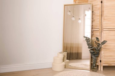 Odadaki ışık duvarının yanındaki büyük ayna. Modern iç tasarım