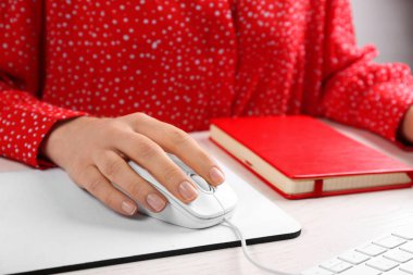 Woman using modern wired optical mouse at office table, closeup clipart