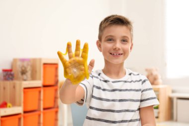 Oyun odasında sümüklü küçük çocuk, eline odaklan.