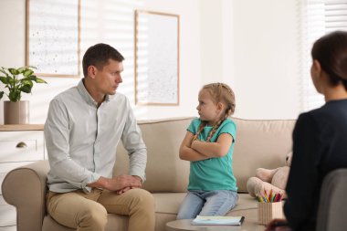 Küçük kız ve babası içeride çocuk psikoterapisti ile randevudalar.