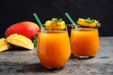 Gri masada taze, lezzetli mango içeceği.