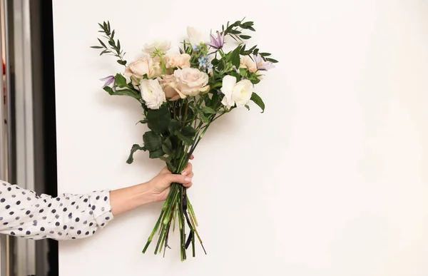 Professional florist with bouquet of fresh flowers in shop, closeup