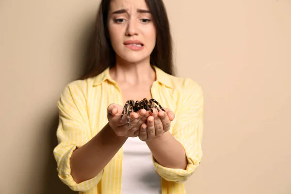 Mujer Joven Asustada Sosteniendo Tarántula Sobre Fondo Beige Aracnofobia Miedo — Foto de Stock