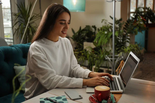 Jeune blogueur travaillant avec un ordinateur portable dans un café — Photo