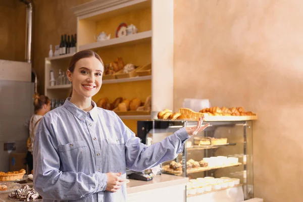 Žena obchodní majitel ukazuje produkty ve své pekárně — Stock fotografie