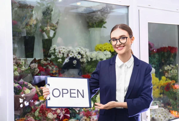 Femme propriétaire d'entreprise holding OPEN sign near flower shop — Photo