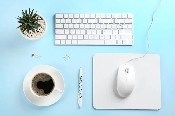 Flat lay composition with mouse and cup of coffee on light blue — Stock Photo, Image