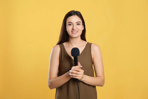 Joven Periodista Con Micrófono Sobre Fondo Amarillo — Foto de Stock